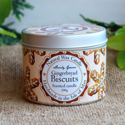 Front view of a gingerbread candle tin. The tin is round and decorated with a label featuring star shaped gingerbread cookies.