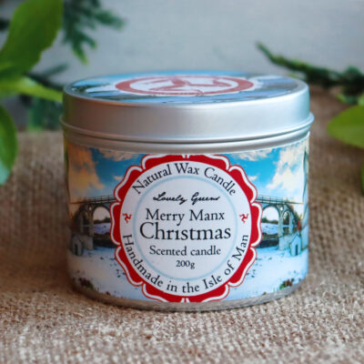 Front view of a Merry Manx Christmas candle tin. The tin is round and decorated with a label featuring a snowy Laxey Wheel.